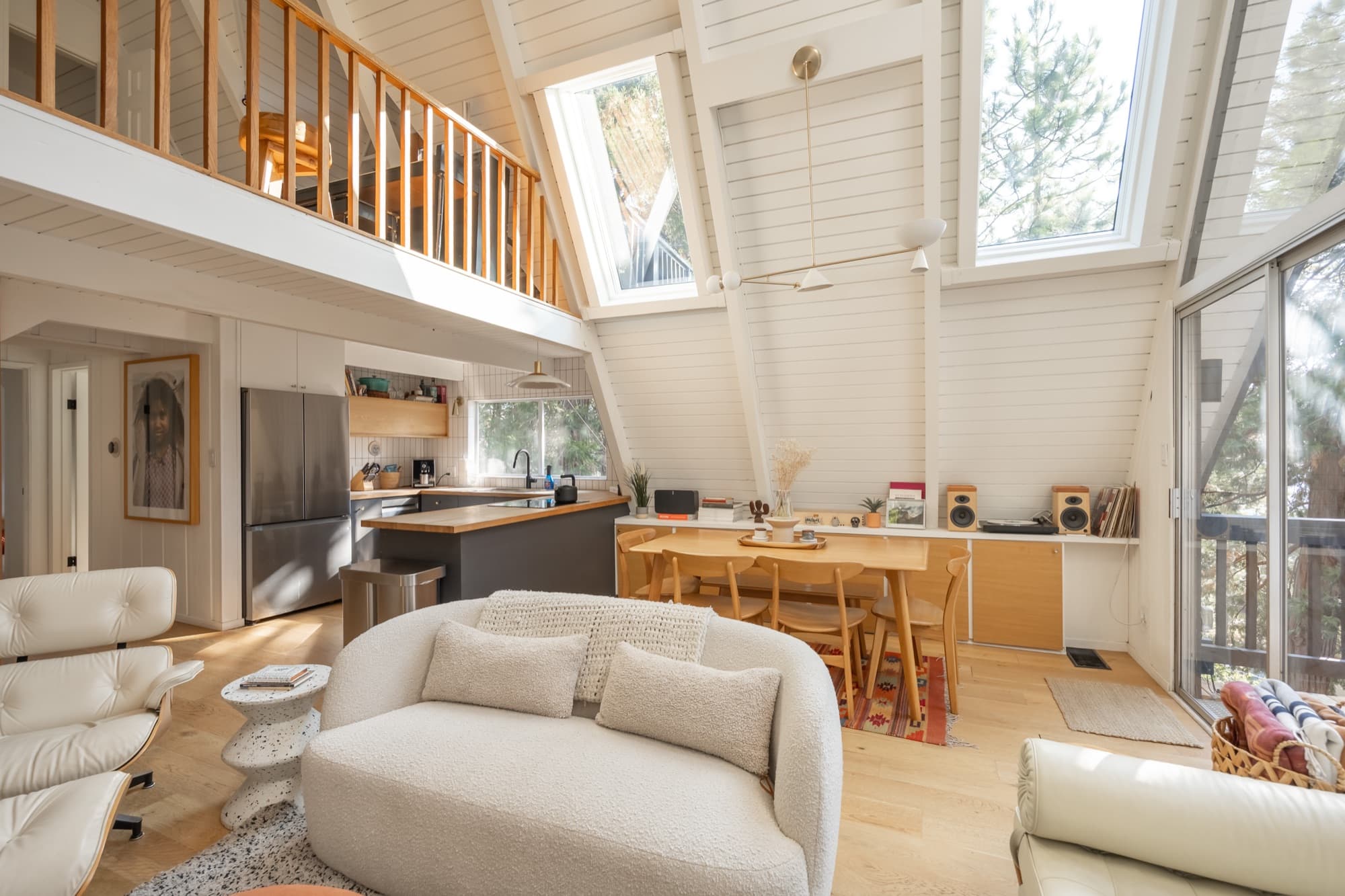 Open plan view showing loft, kitchen, dining area, and living room with natural light